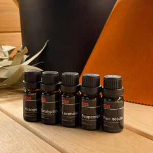 SDS Premium Essential Sauna Oils in front of a sauna whisk and sauna hat.