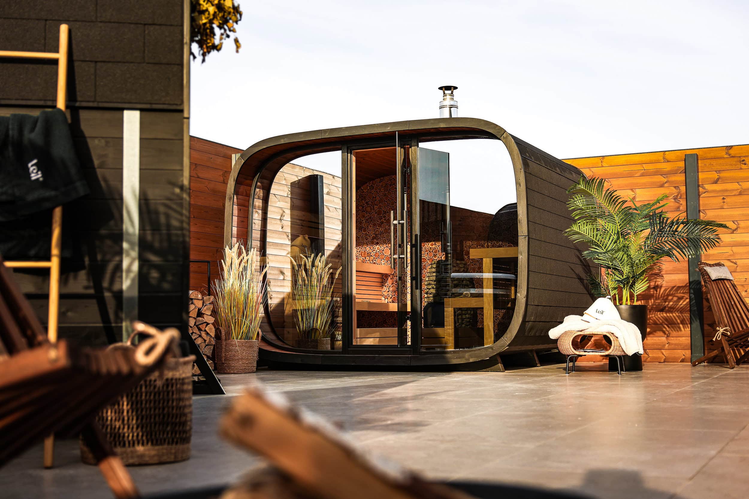Exterior view of the Round Cube® Sauna showcasing its architectural timber form and panoramic glazing