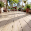 Wooden outdoor deck lined with potted plants, fading into a small wooden table in the background; sunny garden setting.