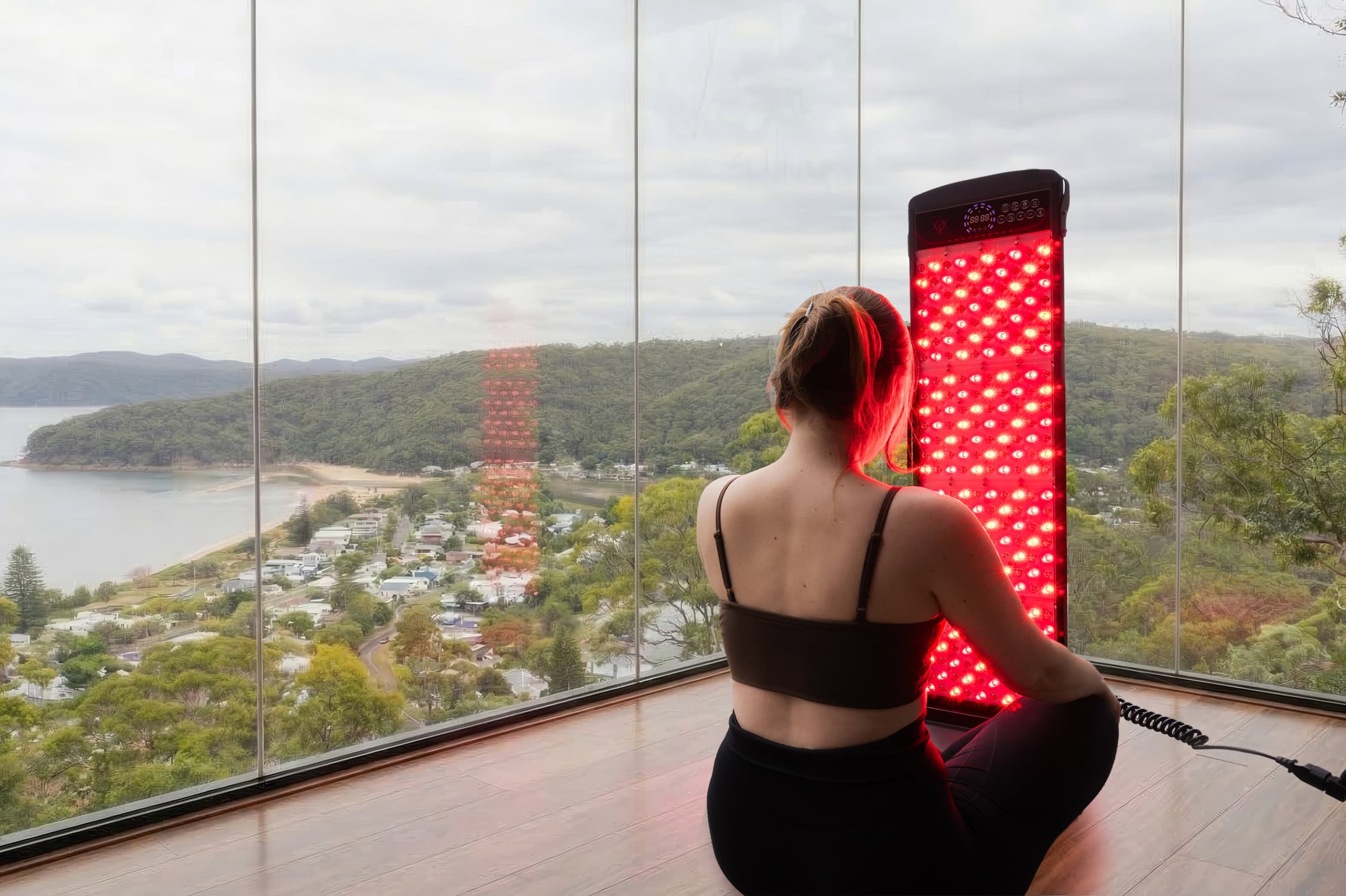 Person sitting on floor with SDS Sunna 1400 Red Light Therapy Device.