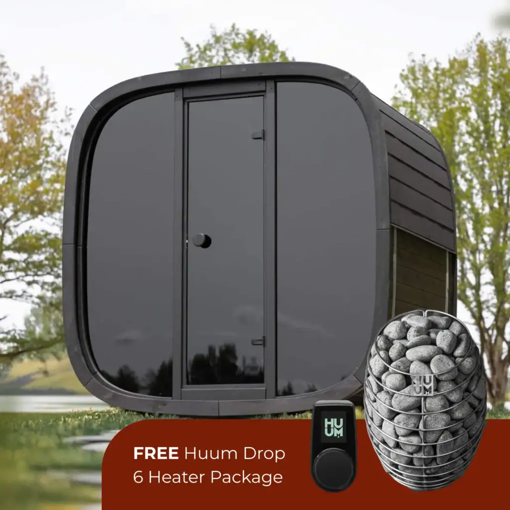 Rounded, dark gray outdoor hot tub with a curved edge, shown outdoors, featuring a red promo banner at the bottom advertising a free heater package and a HUUM control device and stone heater cup.