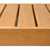 Close-up of a light brown wooden slatted surface with narrow gaps between the boards, like a tabletop or bench.