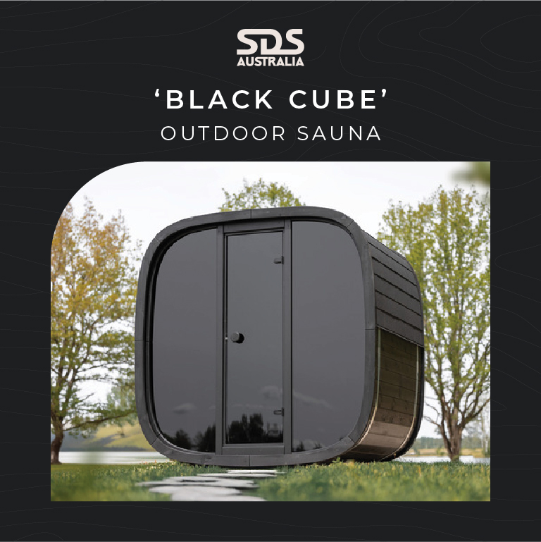 Black rounded outdoor sauna called 'Black Cube' by SDS Australia on a grassy lawn with trees in the background.